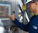 Engineer using control panel at industrial facility, ensuring operational efficiency.