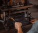 Close-up of worker using industrial press in metalworking process.