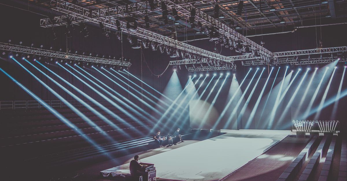 An expansive indoor stage with dramatic lighting setup, ready for a performance or event.